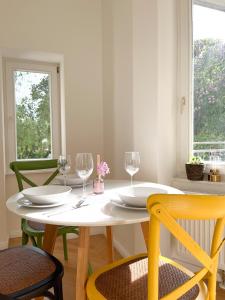 a white table with two chairs and a table with wine glasses at Prorsus Design Apartments in Leipzig