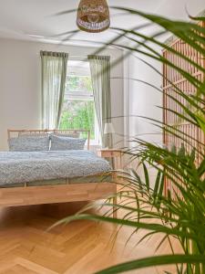 a bedroom with a bed and a potted plant at Prorsus Design Apartments in Leipzig
