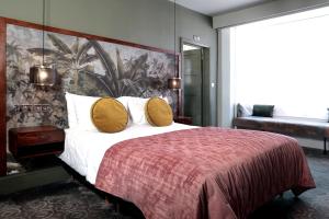a bedroom with a large bed with yellow pillows at The Southern Belle in Brighton & Hove