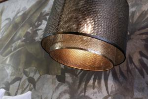 a bronze light hanging from a wall with a mural at The Southern Belle in Brighton & Hove