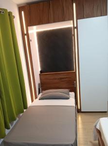 een bed in een kamer met een groene muur bij J&J in Centre de Flacq