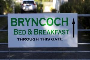 a sign for a bed and breakfast through this gate at Bryncoch in Llannon