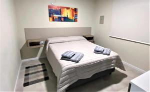 een kleine slaapkamer met een bed met handdoeken erop bij Aires del Valle in San Agustín de Valle Fértil