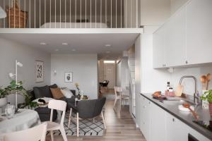 Central Gothenburg Retreat for 6 guests في غوتنبرغ: مطبخ وغرفة معيشة مع أريكة وطاولة