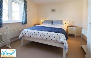 a bedroom with a bed with a blue and white bedspread at 28 Anchorage Way in East Cowes