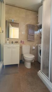een badkamer met een toilet, een wastafel en een wasmachine bij Sun Love calypso in Mijas