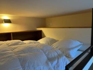 a bedroom with two beds with white sheets and pillows at un nid avec balcon in Saint-Gervais-les-Bains