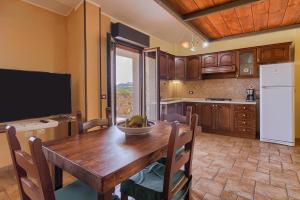 une cuisine avec une table en bois et une télévision dans l'établissement Ferienwohnung Panorama, Wohlfühloase Auszeit, à Gonnesa