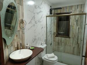 a bathroom with a sink and a toilet and a shower at Pousada Mirante da Lua in Lavras Novas
