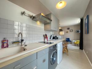 uma cozinha com um lavatório e uma máquina de lavar roupa em Au Coin de YourHostHelper em Reims