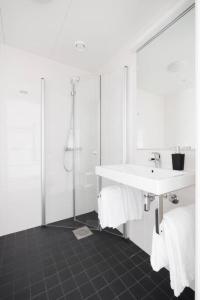 a white bathroom with a sink and a shower at Contemporary 2-BR with Workspace in Kottla