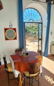 una sala da pranzo con tavolo e una grande finestra di Private House in the Heart of Nature, Sea View a Moclinejo