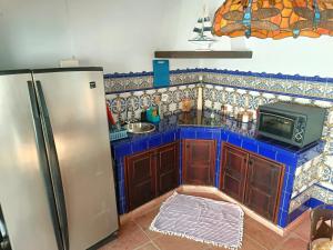 una cucina con frigorifero e forno a microonde di Private House in the Heart of Nature, Sea View a Moclinejo