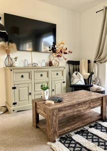 uma sala de estar com uma mesa de café em madeira e uma cómoda em Central, Cosy Home with Large Garden & Parking, Bournemouth em Bournemouth