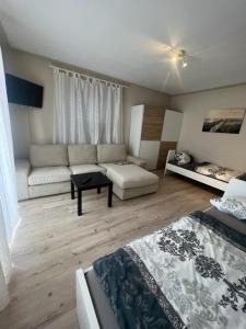 een woonkamer met een bank, een bed en een tafel bij Sol Ferienwohnung in Rodenbach