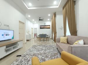 een woonkamer met een bank en een tv bij Aida homestay Kuala terengganu/Kuala nerus in Kuala Terengganu