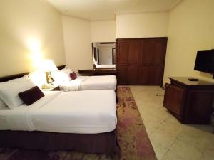 um quarto de hotel com duas camas e um espelho em فندق روتانة الفرسان بالحمرا em Jeddah