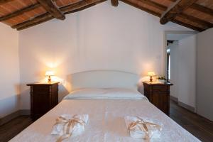 [L'Antico Casale] A Timeless Retreat in Cortona 5* في كورتونا: غرفة نوم بسرير كبير وعليها مصباحين