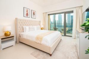 ドバイにあるPrime Retreats @ Burj Royale By Emaarの白いベッドルーム(ベッド1台、大きな窓付)