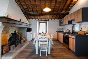[L'Antico Casale] A Timeless Retreat in Cortona 5* في كورتونا: مطبخ مع طاولة وغرفة طعام