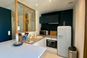 a kitchen with a white refrigerator and green cabinets at Bel appt 5 pers proche mer avec grande terrasse in Le Touquet-Paris-Plage +16 photos