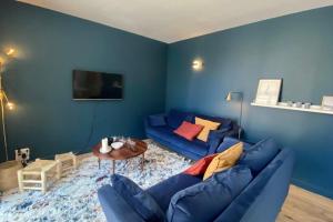a blue living room with a blue couch and a table at Cosy flat close to the sea with large terrace in Le Touquet-Paris-Plage