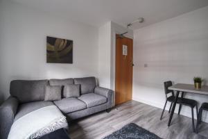a living room with a couch and a table at #59 Phoenix Court By DerBnB, Modern 1 Bedroom Apartment, Wi-Fi, Netflix & Within Walking Distance Of The City Centre in Sheffield