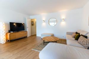 sala de estar con sofá y TV en Magnificent town-centre apartment with two terraces 5 people, en Le Touquet-Paris-Plage
