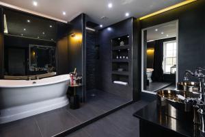 a bathroom with a tub and a large mirror at The Old Manse of Blair, Boutique Hotel & Restaurant in Blair Atholl