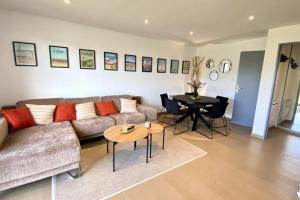 ein Wohnzimmer mit einem Sofa und einem Tisch in der Unterkunft Superb duplex with lake view for 6 people in Le Touquet-Paris-Plage