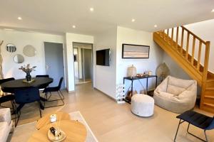 a living room with a staircase and a table and chairs at Superb duplex with lake view for 6 people in Le Touquet-Paris-Plage