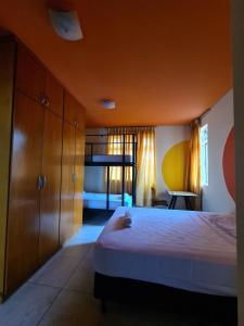 a bedroom with a large bed and wooden cabinets at Poente Hostel in Belo Horizonte