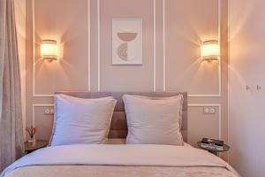 Suite Eiffel- Perfect location في باريس: غرفة نوم بسرير مع مصباحين ومخدتين
