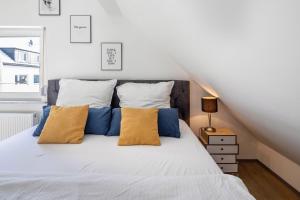 ein Schlafzimmer mit einem weißen Bett und gelben Kissen in der Unterkunft Hue Space Air in Kassel