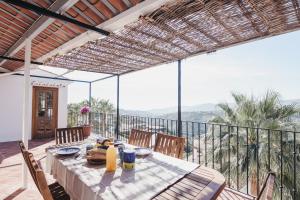a dining room with a table and chairs on a balcony at Casa La Martina Frigiliana in Frigiliana