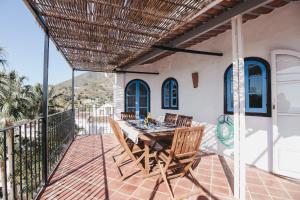 a patio with a table and chairs on a balcony at Casa La Martina Frigiliana in Frigiliana