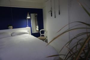 a bedroom with a white bed and a chair at Ben & Maria's Guesthouse in Bath