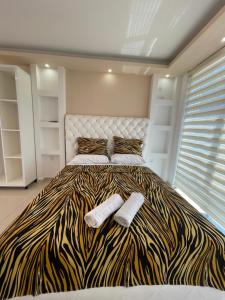 a bedroom with a zebra print bed with two socks at Queen Kodre Apartments in Ulcinj