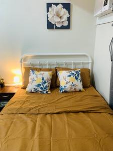 a bed with yellow sheets and pillows in a room at EZ Cityscape Studio at Loop Towers Limketkai in Cagayan de Oro