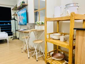 a room with a table and a shelf with dishes at EZ Cityscape Studio at Loop Towers Limketkai in Cagayan de Oro