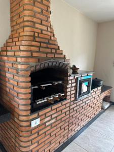 a brick fireplace in a living room at Sítio Maravilhoso a 40min de BH! in Lagoa Santa