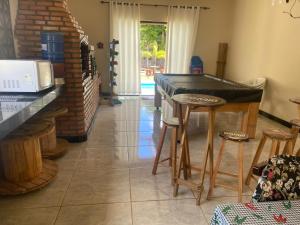 a kitchen with a counter and stools in a room at Sítio Maravilhoso a 40min de BH! in Lagoa Santa