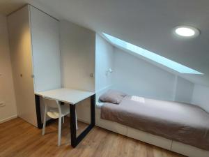 een kleine slaapkamer met een bed en een bureau bij Casa Gray 2 in Koper