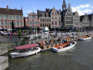 Un groupe de bateaux dans une rivière avec des gens sur eux dans l'établissement Wonderful stay Monet, à Gand