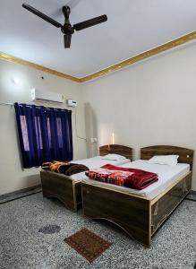 a bedroom with two beds and a ceiling fan at Hotel moon light in Rājgīr