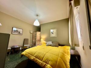 een slaapkamer met een bed met een geel dekbed bij Apartamento Royal Centro de Ronda in Ronda