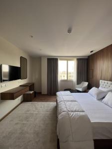 een hotelkamer met een groot bed en een flatscreen-tv bij The Home Boutique Hotel Pyramids Inn in Caïro