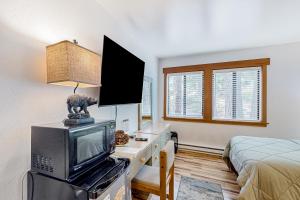 a bedroom with a bed and a tv and a bed at Granlibakken Getaway - B in Tahoe City