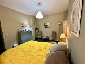 a bedroom with a yellow bed in a room at Apartamento Royal Centro de Ronda in Ronda