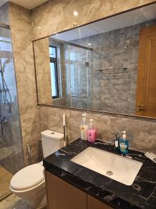 a bathroom with a sink and a toilet and a mirror at R&F Princess Cove JB Apartment Suites By SC Homestay in Johor Bahru